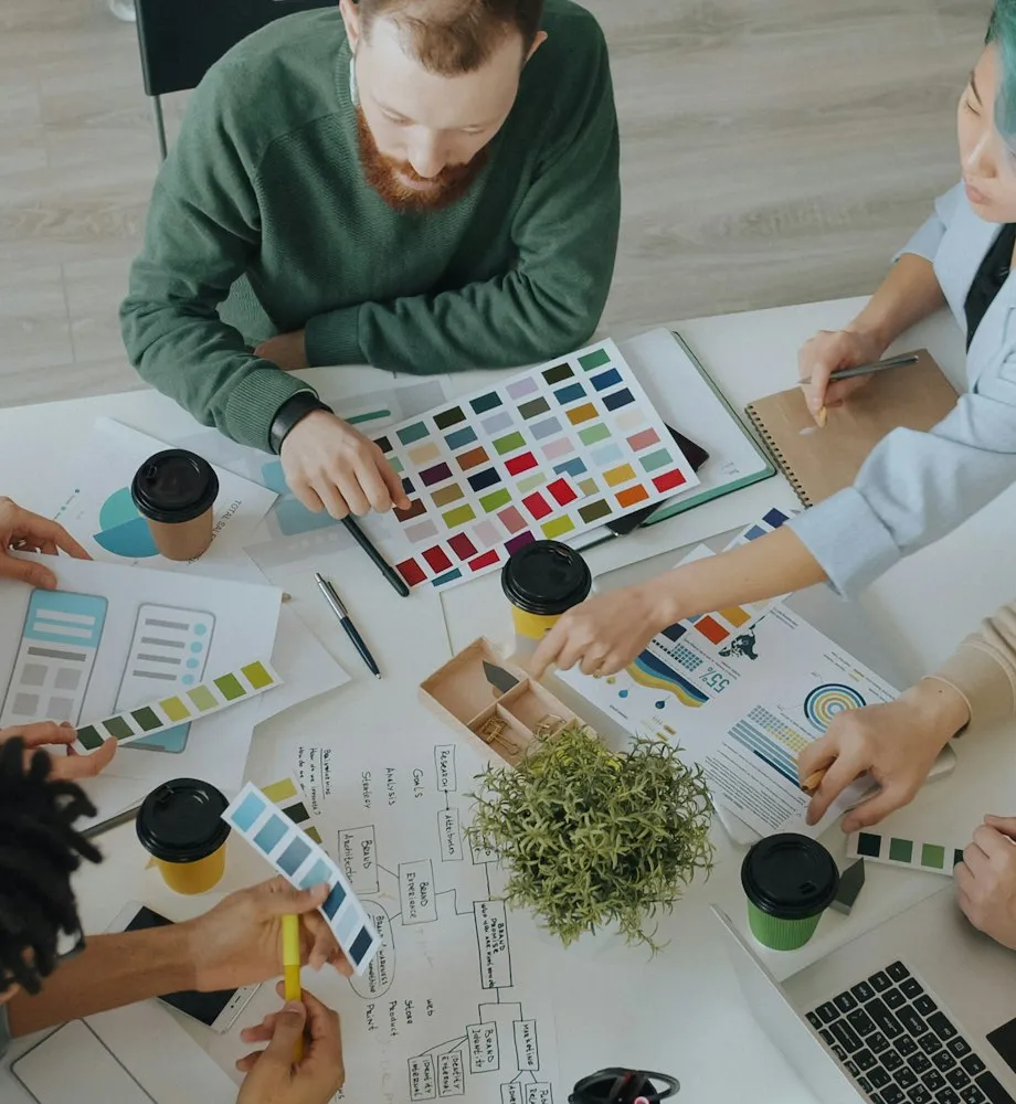 People collaborating around a table with colour swatches and charts